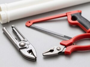 Różne narzędzia do cięcia rur PCV: obcinak krążkowy, piła ręczna i nożyce