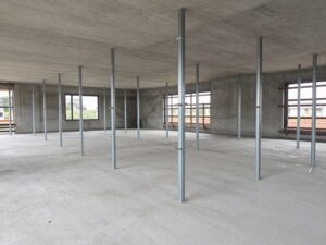 Stemple budowlane podpierające strop monolityczny z widocznym rozstawem