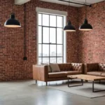 Salon w stylu loft z ceglaną ścianą, betonową podłogą i industrialnym oświetleniem